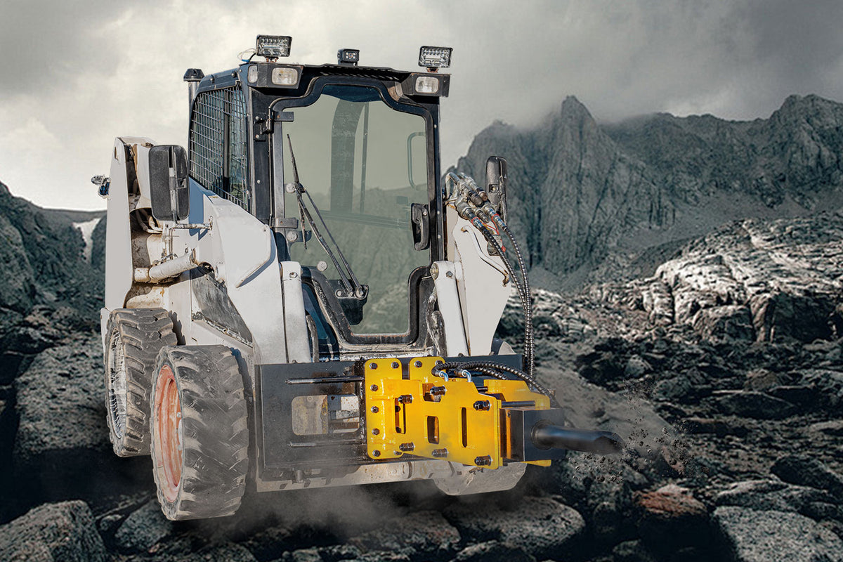 Yellow hydraulic hammer breaker attachment on skid steer loader in rocky mining site