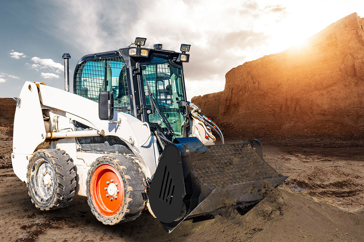 White skid steer loader with concrete mixing bucket attachment on construction site