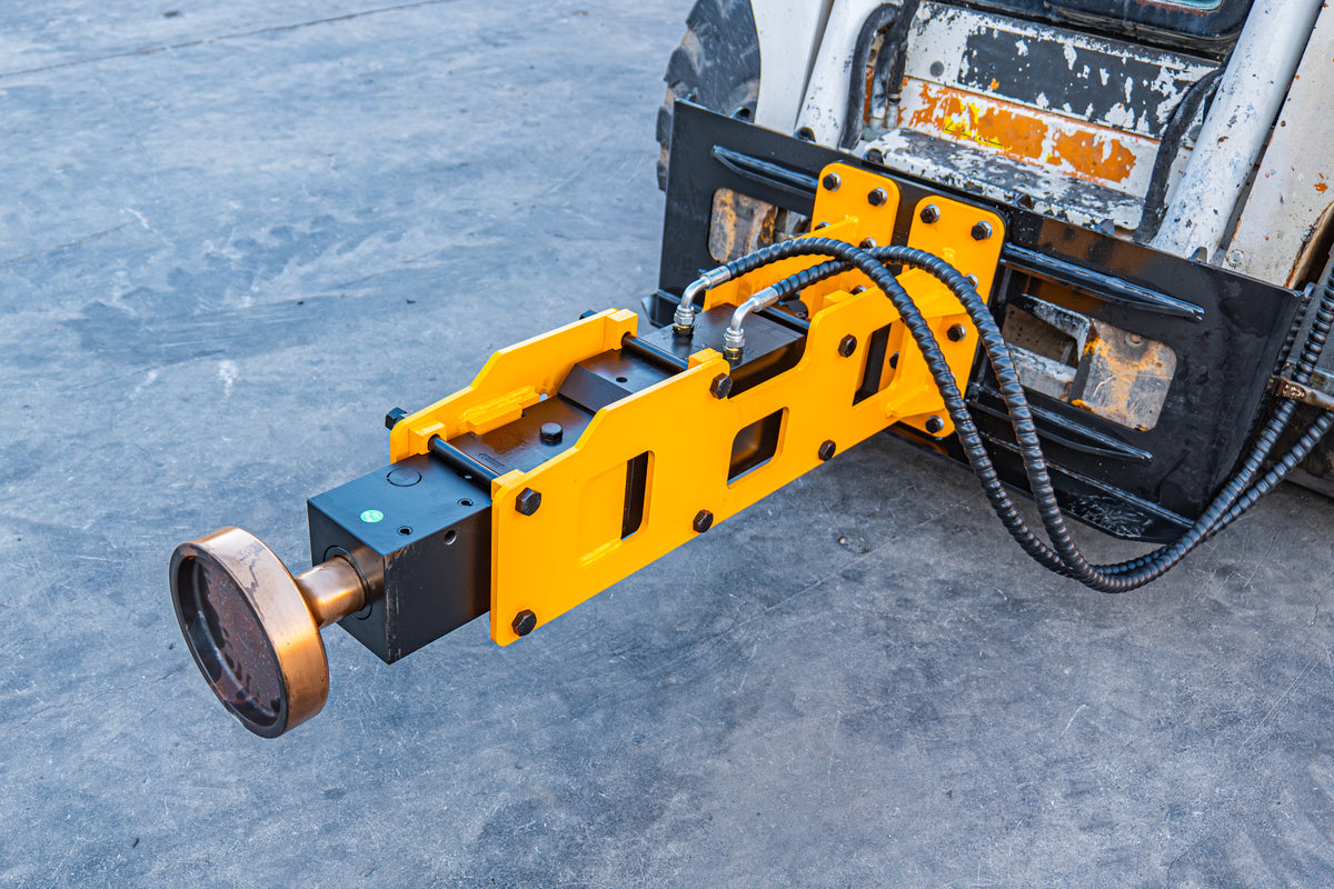 Hydraulic pile driver attachment for skid steer loader with yellow steel frame and hoses