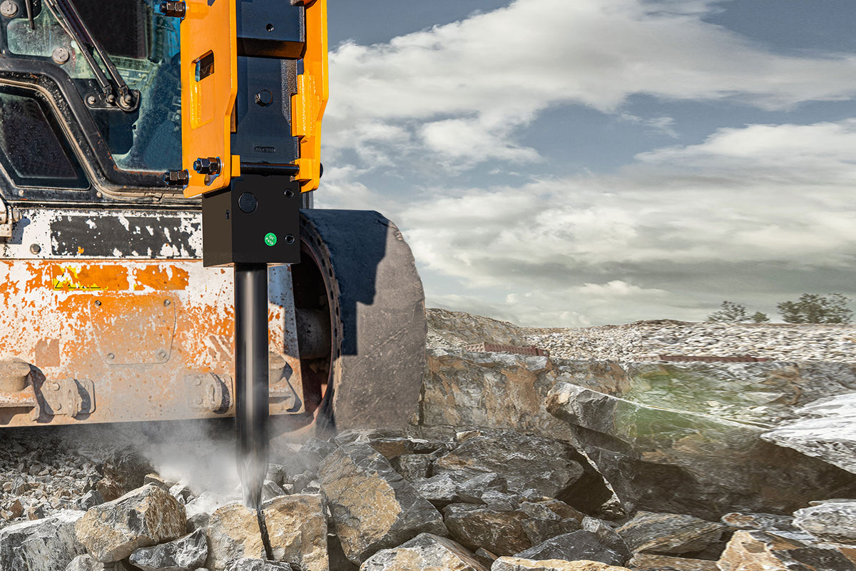 Skid steer hydraulic hammer breaker attachment crushing rocks at a demolition site