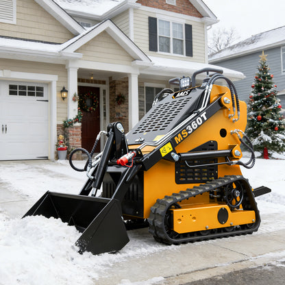 Yellow tracked machine with a black blade in front of a house.